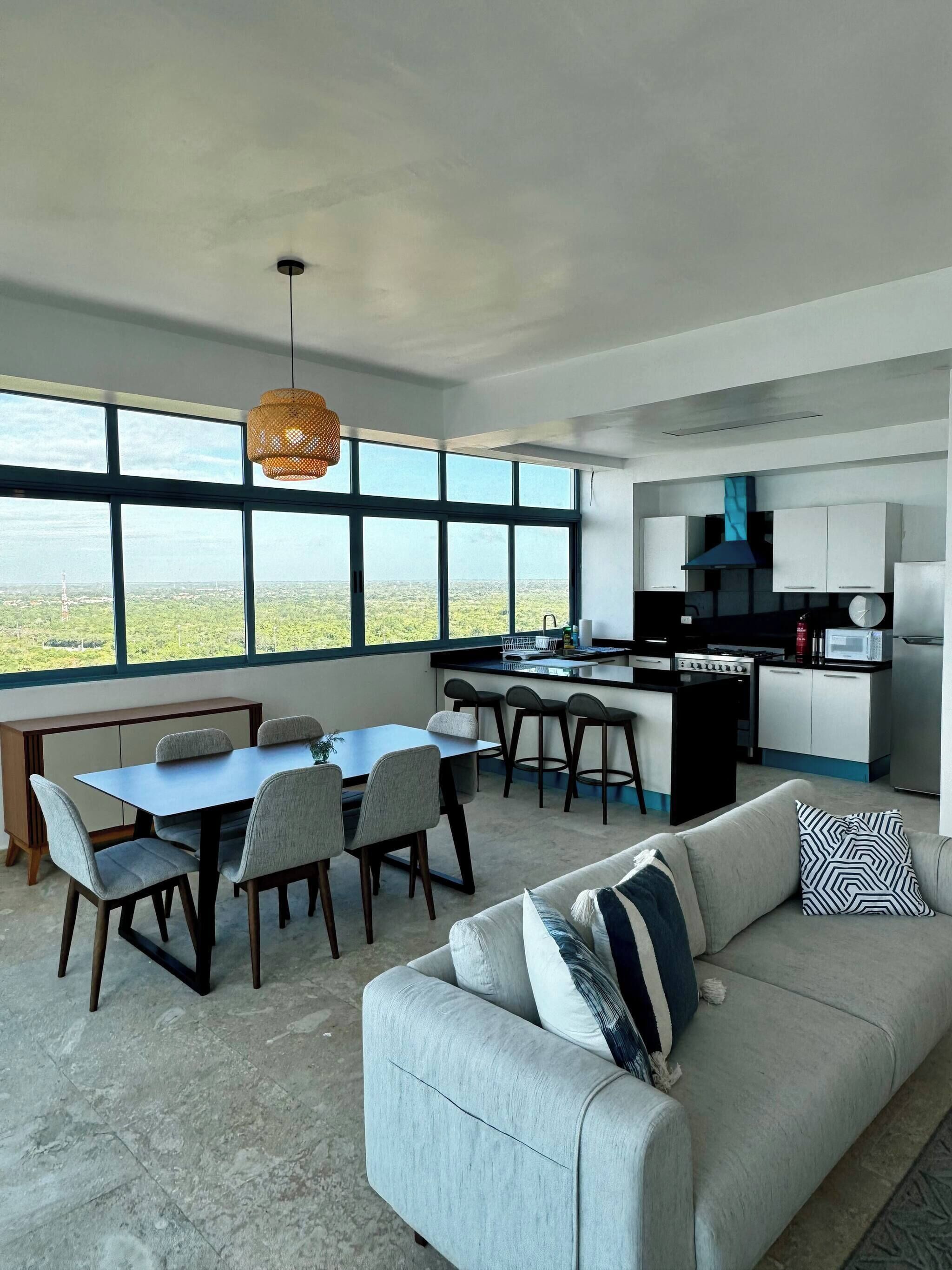 A modern interior with a dining area, kitchen, and a sofa.