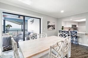 Ein modernes Interieur mit Essbereich, Küche und einem Balkon mit Aussicht.