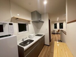 Apartamento Deluxe, vistas al jardín | Cocina privada | Frigorífico, microondas, placa de cocina y utensilios de cocina