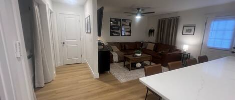 A modern living room with a sofa, coffee table, and dining area.