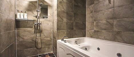 A modern bathroom with a freestanding bathtub, a shower area, and a tiled floor.