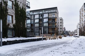 Ein modernes Mehrfamilienhaus mit mehreren Etagen, großen Fenstern und Balkonen.