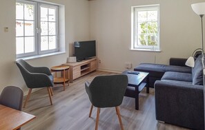 A living room with a sofa, two chairs, a TV, and a small table. - 4 bedroom beautiful home in Farsø (Farsø)