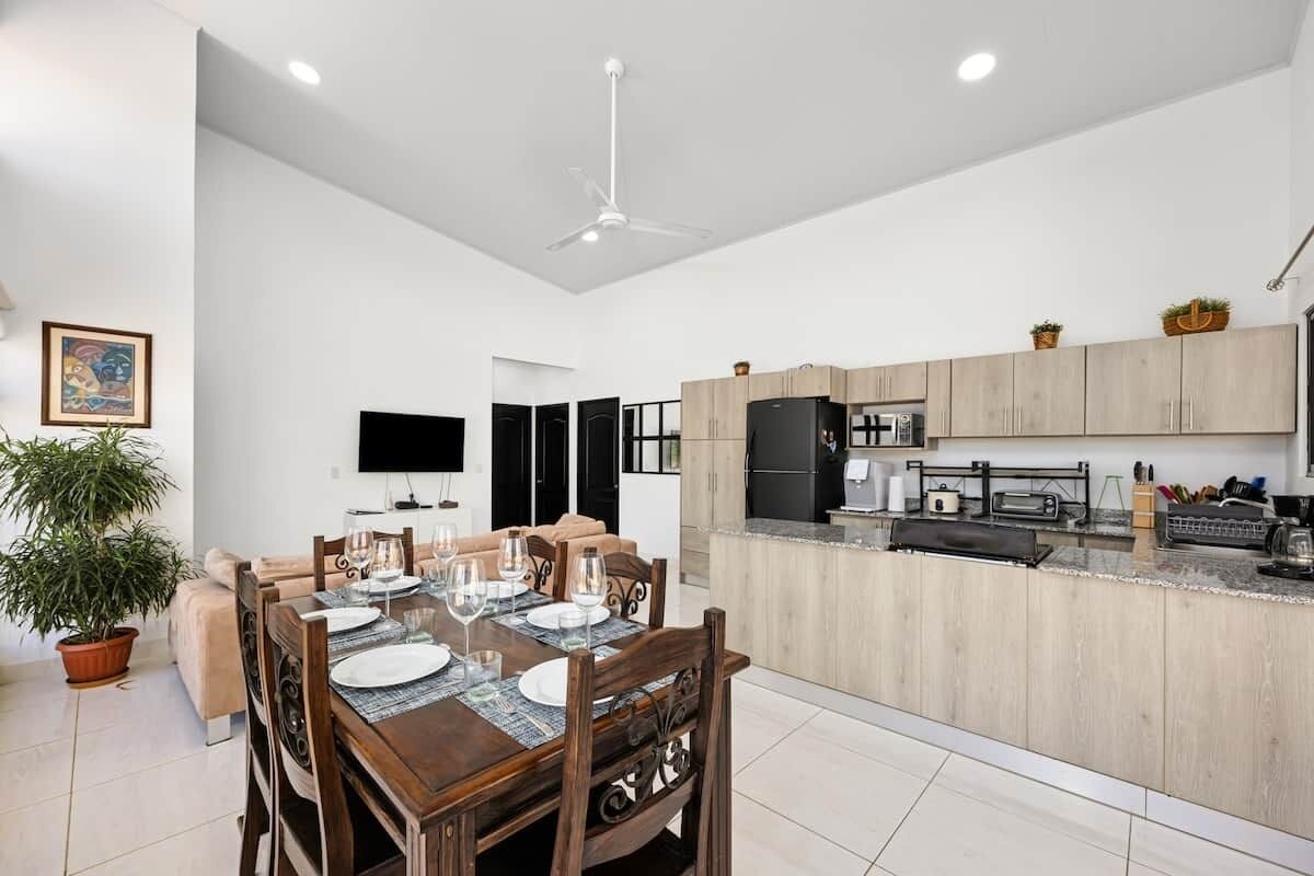 Une cuisine moderne avec des meubles en bois, un îlot central intégré et un téléviseur à écran plat.