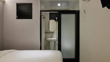 A small, modern bathroom with a toilet, sink, and mirror.