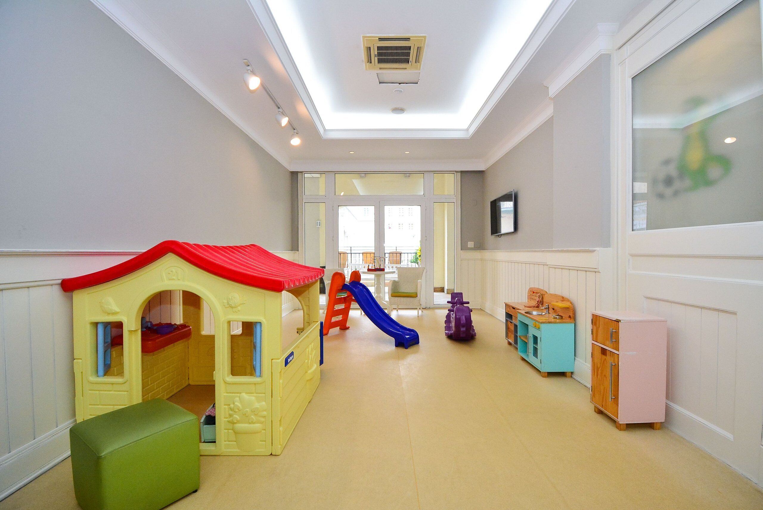 A children's play area with a slide, playhouse, and storage cabinets.