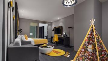 A modern hotel room with a bed, sofa, desk, and a colorful teepee.