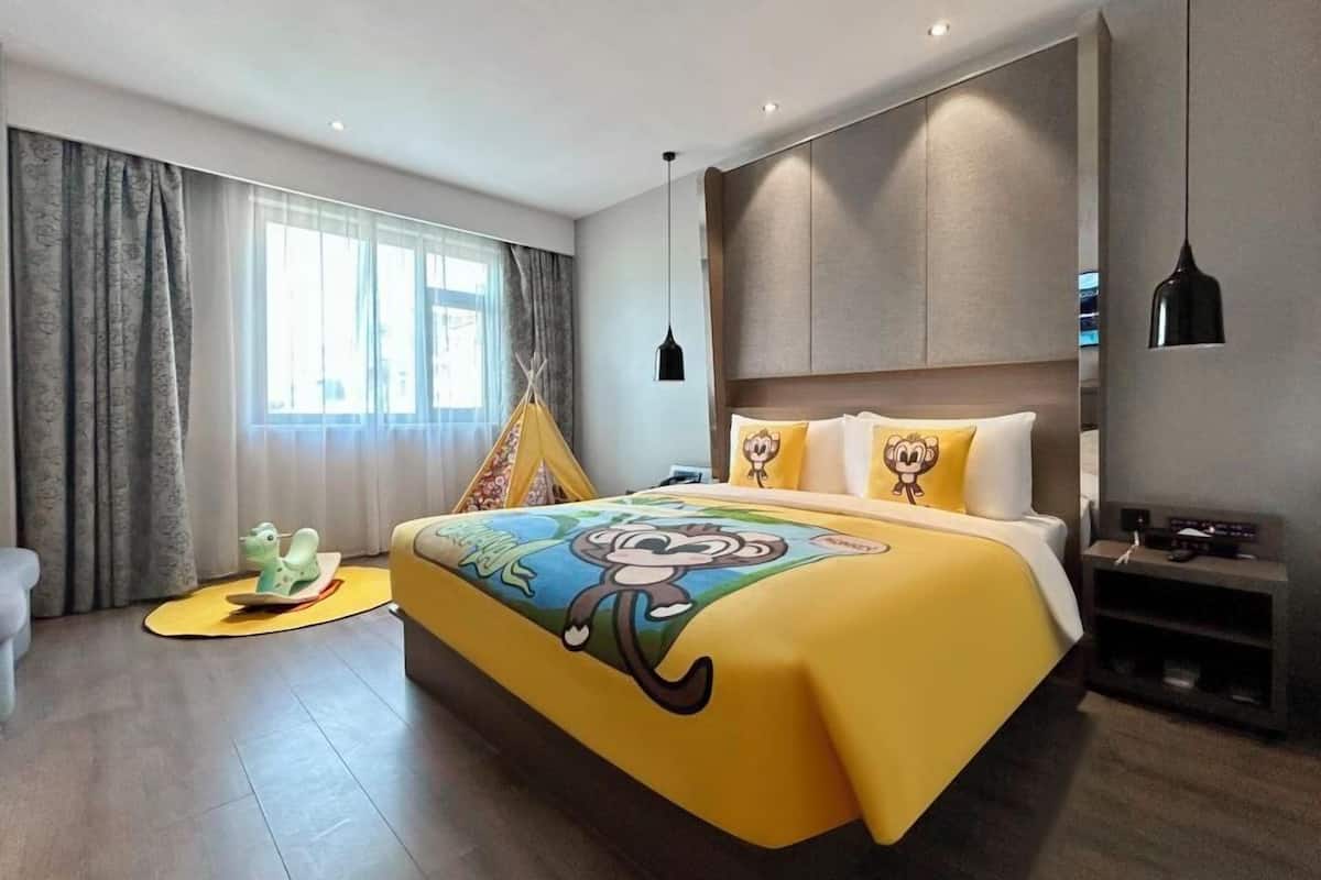 Une chambre d’hôtel moderne avec un grand lit, une télévision et une fenêtre avec des rideaux.