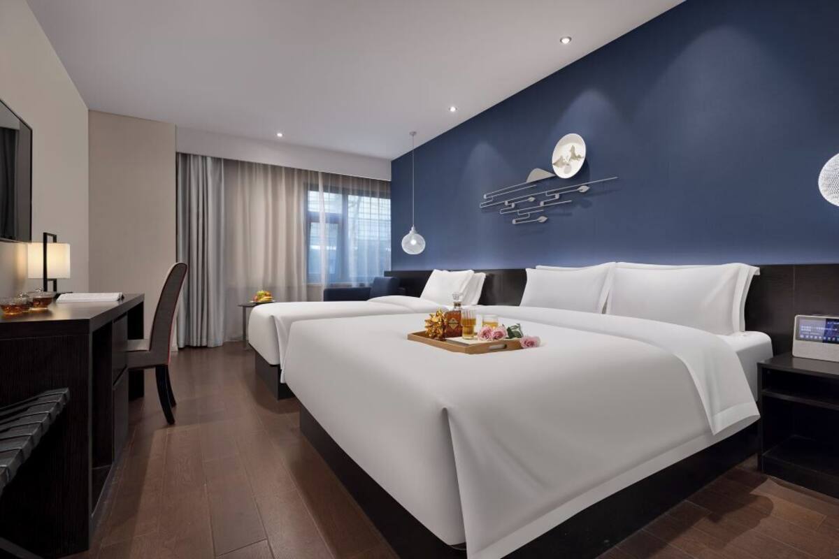 Une chambre d’hôtel avec un grand lit, un bureau et une chaise.