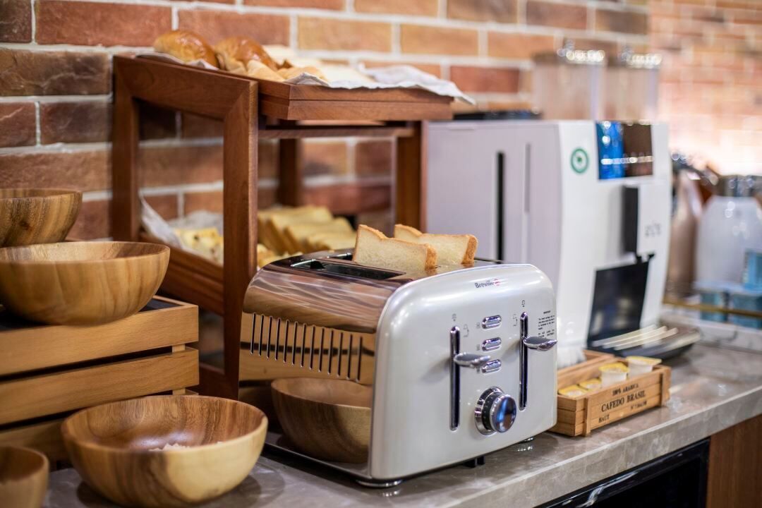 Una zona de cocina con un tostador, cuencos de madera y una cafetera.