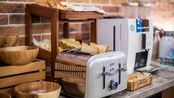 Una zona de cocina con un tostador, cuencos de madera y una cafetera.