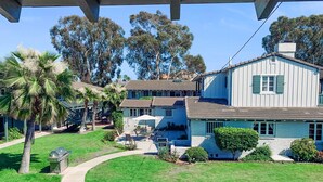 A two-story house with a patio, a barbecue grill, and a small garden. - 3080 Lincoln - Unit 12 (Carlsbad)
