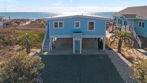 Ein zweistöckiges Haus mit einer Veranda und Blick auf das Meer.