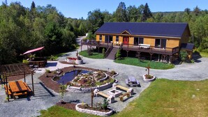 A lodge with a deck, outdoor seating, and a pond. - 1800ml - As Seen on TV 1 Mile From Skiing, Great Views, hot Tub, Fire Pit, Beach! Pool gym Passes (Bretton Woods)