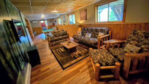 A spacious living area with wooden floors, a pool table, and a sofa with patterned cushions. - 1800ml - As Seen on TV 1 Mile From Skiing, Great Views, hot Tub, Fire Pit, Beach! Pool gym Passes (Bretton Woods)
