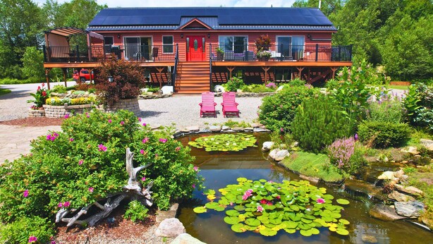 A two-story building with a red exterior and a balcony. - 1800ml - As Seen on TV 1 Mile From Skiing, Great Views, hot Tub, Fire Pit, Beach! Pool gym Passes (Bretton Woods)