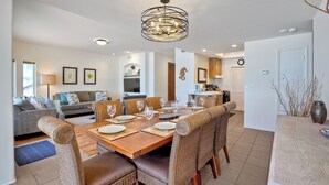 A dining area with a wooden table set for six, surrounded by wicker chairs. - 2751 Ocean Street (Carlsbad)