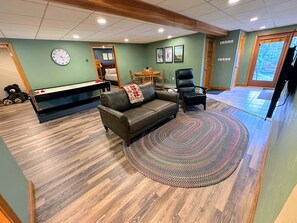 A living room with a sofa, a coffee table, a fireplace, and a large window. - Fc43 Renovated Cozy Spacious Cottage With AC, air Hockey, Wifi Close to ski Trails! (Bretton Woods)