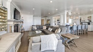 Un salon spacieux avec un canapé d’angle, une table basse et une cheminée.