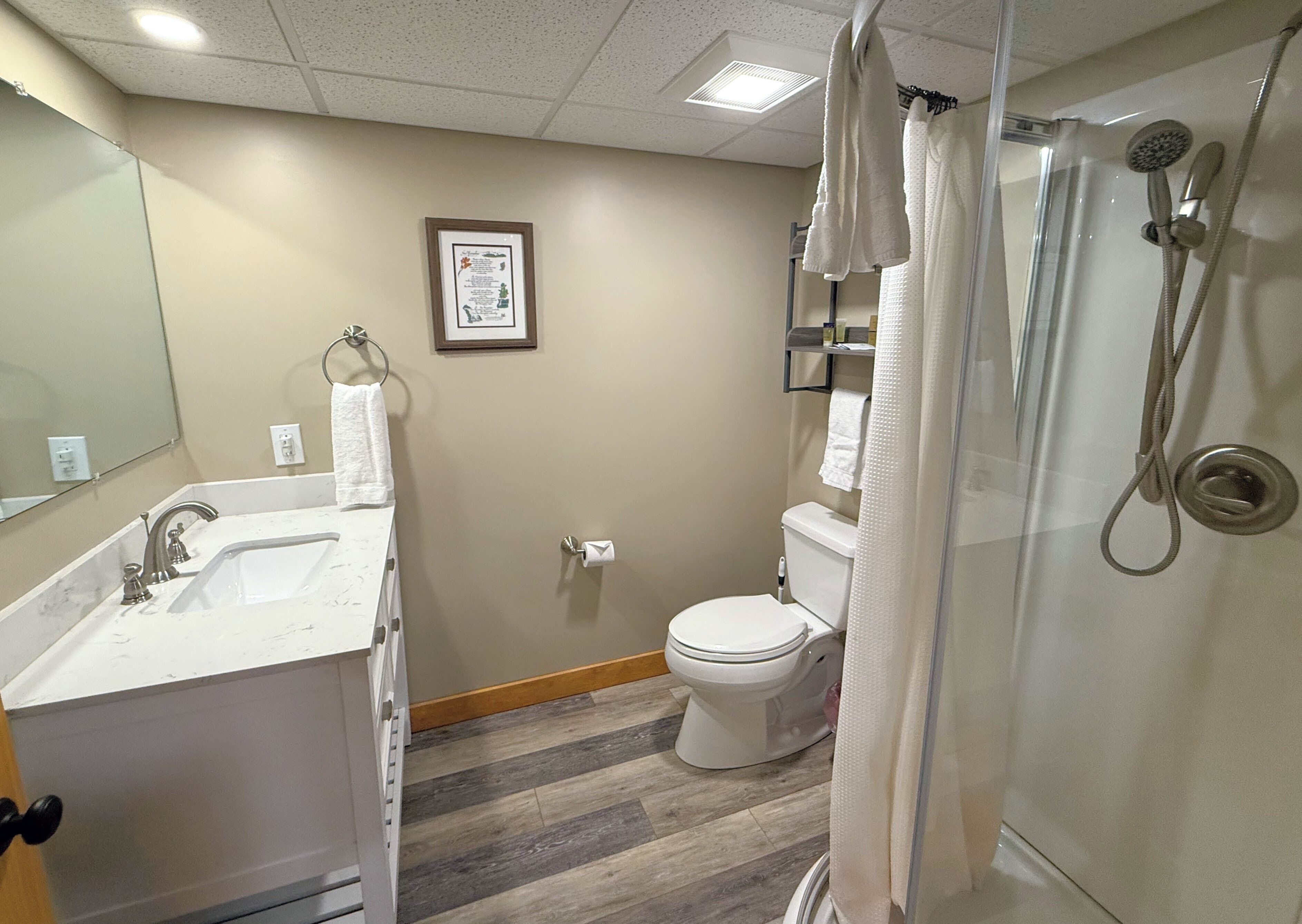 A bathroom with a sink, toilet, and shower.