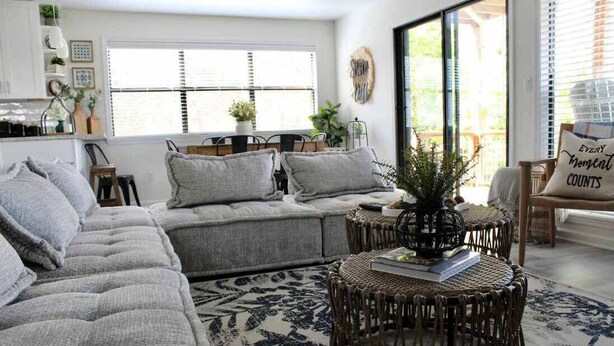 A cozy living room with a grey sectional sofa, a round wicker coffee table, and a patterned rug. - Shore Nuff, a Relaxing 4-bedroom Vacation Home on Canyon Lake (Canyon Lake)