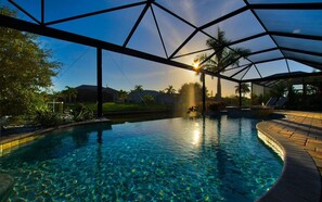 Ein Pool mit klarem Wasser, umgeben von einer überdachten Fläche mit geometrischer Dachkonstruktion.