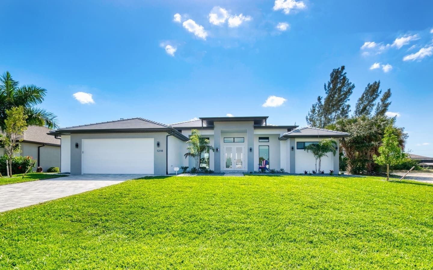 A modern two-story house with a well-maintained lawn, a garage, and a driveway.