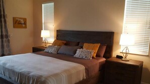 Una camera da letto con un letto grande, due comodini e un tavolino con una lampada.