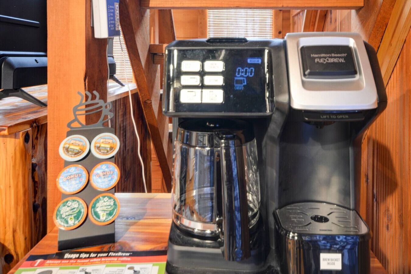 Une machine à café Hamilton Beach Flexbrew dotée d’un écran numérique, d’une verseuse et d’un compartiment pour dosettes de café, avec différents arômes disponibles.