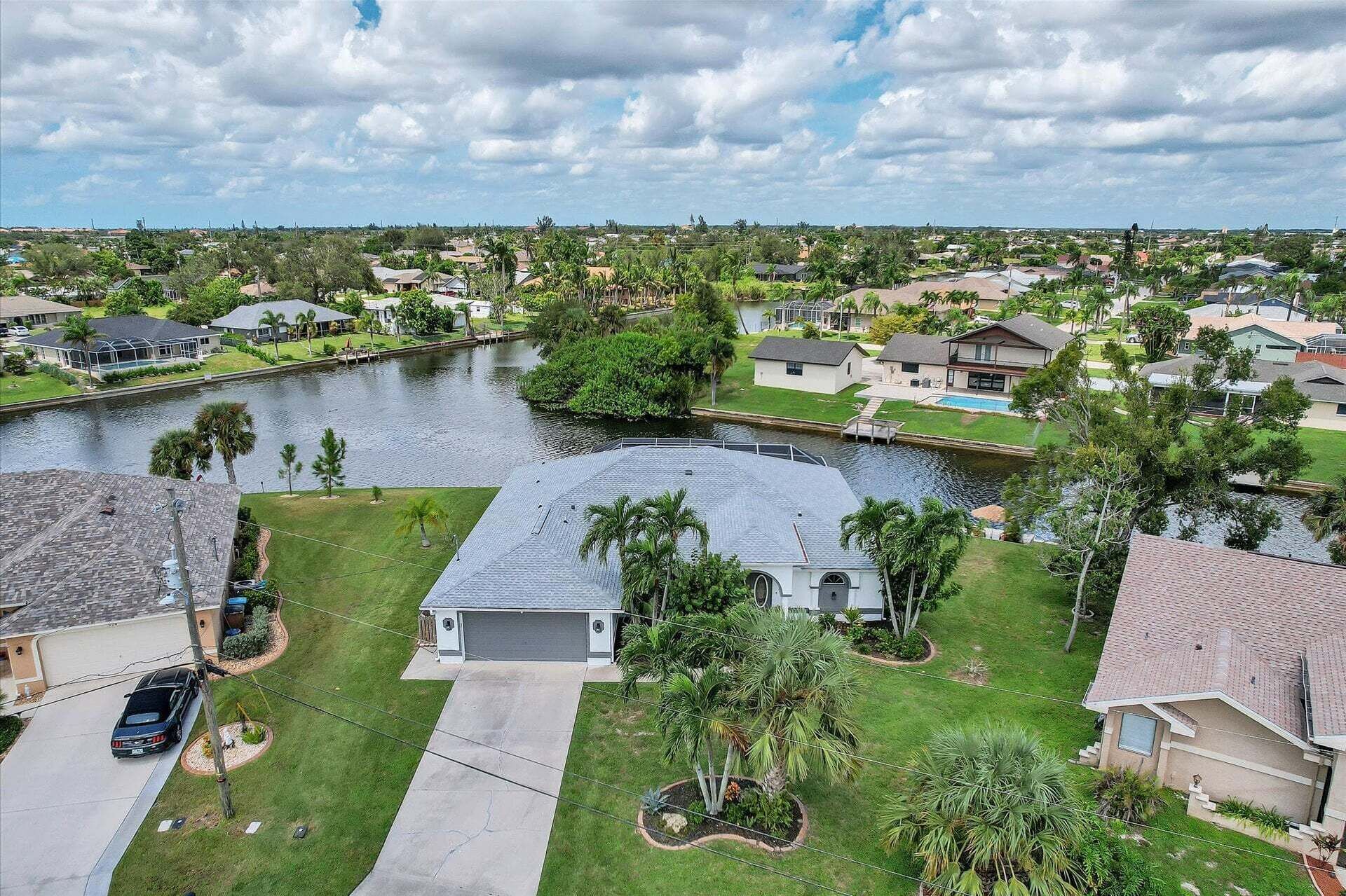 A residential area with houses, a body of water, and a small building with a garage.