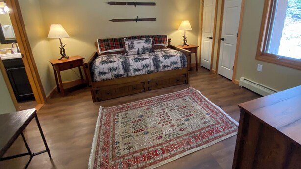 A bedroom with a bed, two bedside tables, a nightstand, a rug, and a window. - Mwp25 Updated 3 bed 3 Bath Condo With Mountain ski Slope Views in Bretton Woods (Bretton Woods)
