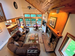 A cozy living room with a fireplace, comfortable seating, and large windows overlooking a deck. - Mwp15 (Bretton Woods)