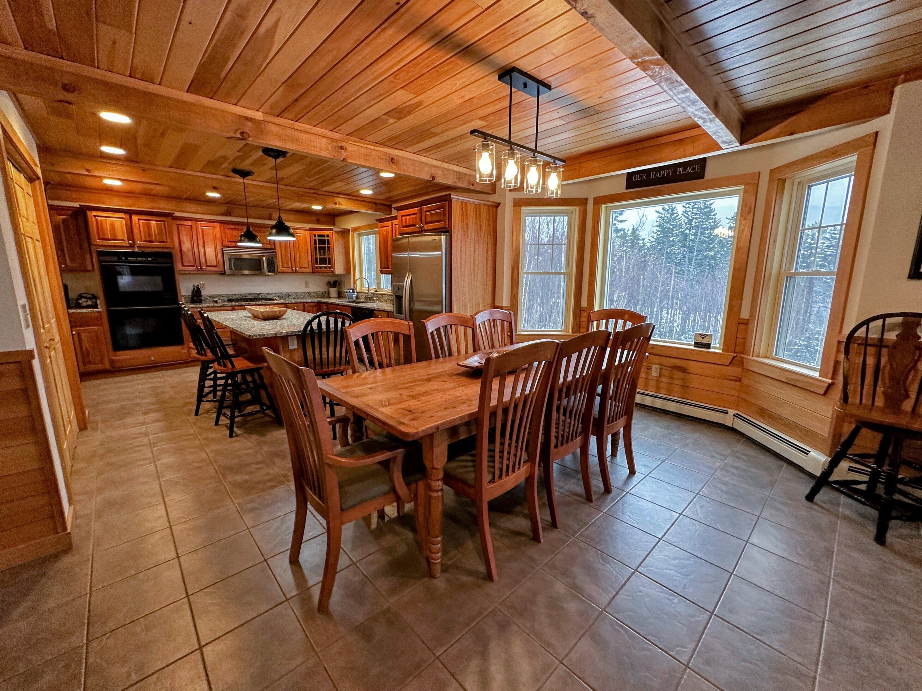 Un interior de madera con comedor, cocina y amplios ventanales.