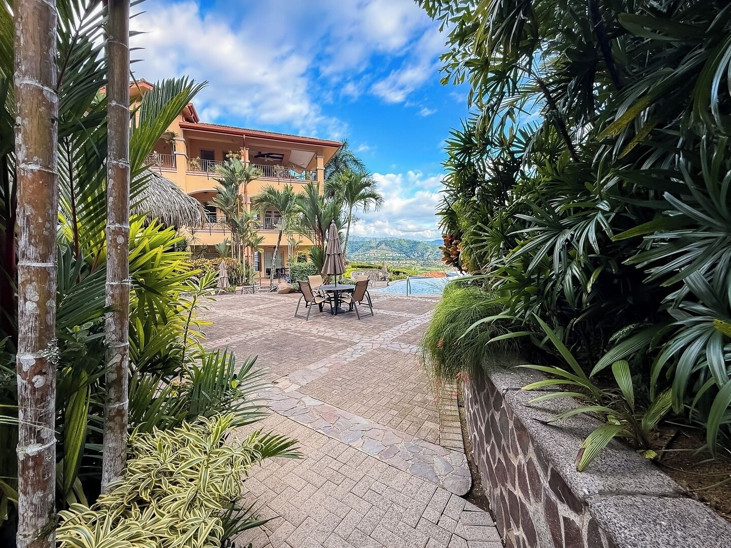 Ein Resort mit Pool, Sitzgelegenheiten im Freien und üppiger Bepflanzung.