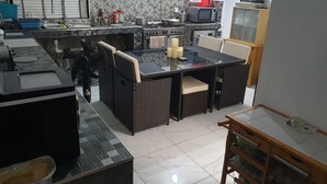 A compact kitchen with a dining area, a gas stove, a microwave, and a small refrigerator.