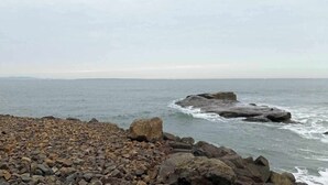 Una costa rocosa con olas rompiendo contra grandes rocas.