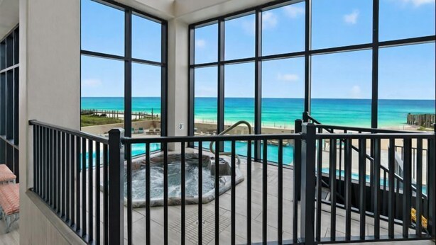 Un balcone con vasca idromassaggio e vista sull'oceano.