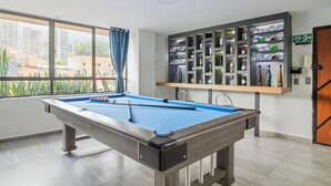A pool table in a room with a view of buildings outside. - 2bedroom with pooltable 1 block -Lleras  (Medellín)