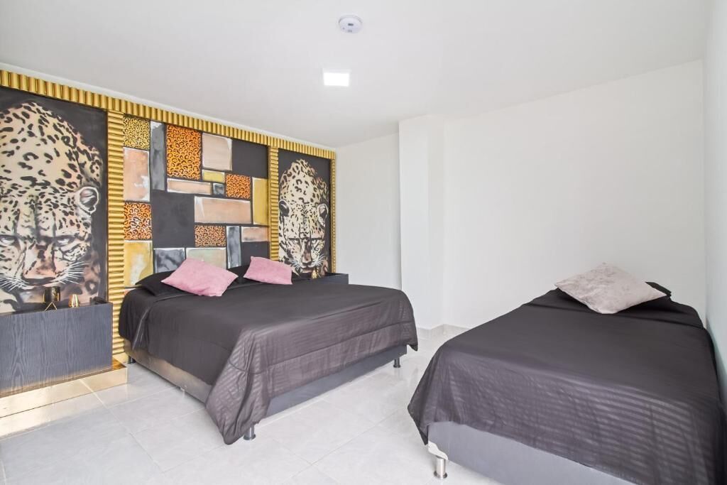 A hotel room with two beds, a decorative wall with a leopard print, and a modern design.