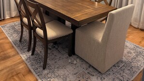 A dining area with a wooden table, four upholstered chairs, a patterned rug, and a ceiling light fixture. - Entire home just 10 minutes from Pittsburgh's North Shore (Glenshaw)