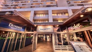 A waterfront dining area with signs for Dundee's Waterfront Dining and Ochre. - Cairns Harbour Haven | Marina Views | Pool & Spa | near Reef Terminal (Cairns City)
