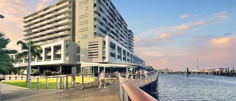Un hôtel moderne à plusieurs étages, offrant une vue sur le front de mer et doté d’une promenade en bois.
