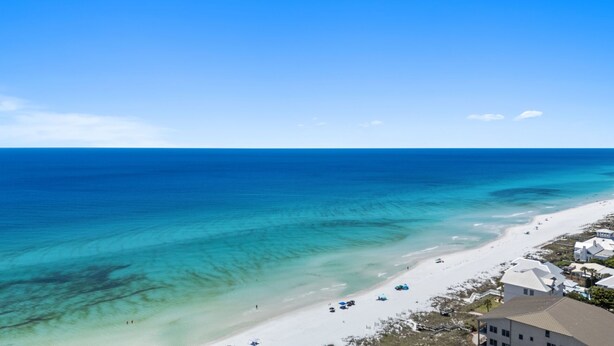 A coastal view with a beach, clear blue water, and a few buildings along the shore. - Large Family Getaway – Pool, Golf Cart, Sleeps 17 (Santa Rosa Beach)