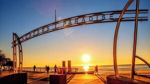 A metal archway with the words "SURFERS PARADISE" against a sunset backdrop. - Golfside Escape – Stylish 3BR Townhouse in Robina (Robina)