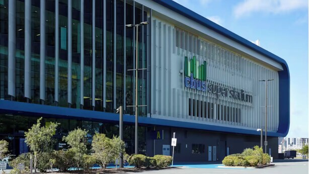 A modern building with a large glass facade, a prominent 'cbus superstore' sign, and a parking lot with trees. - Golfside Escape – Stylish 3BR Townhouse in Robina (Robina)