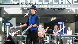 A band performing on stage with a sign reading "Cavill Lane Through to Beach". - Golfside Escape – Stylish 3BR Townhouse in Robina (Robina)