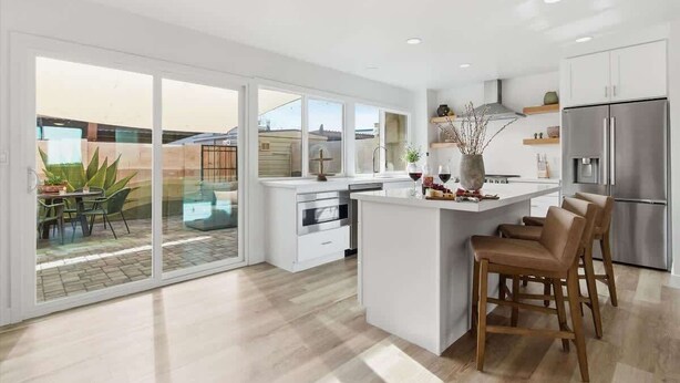 A modern kitchen with a large island, sliding glass doors to a patio, and a stainless steel refrigerator. - Hideaway - In Old Town Scottsdale-Walk to Downtown (Scottsdale)