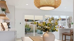 A modern kitchen with a large island, a dining area with a table and chairs, and a large window with a view of the outside. - Hideaway - In Old Town Scottsdale-Walk to Downtown (Scottsdale)