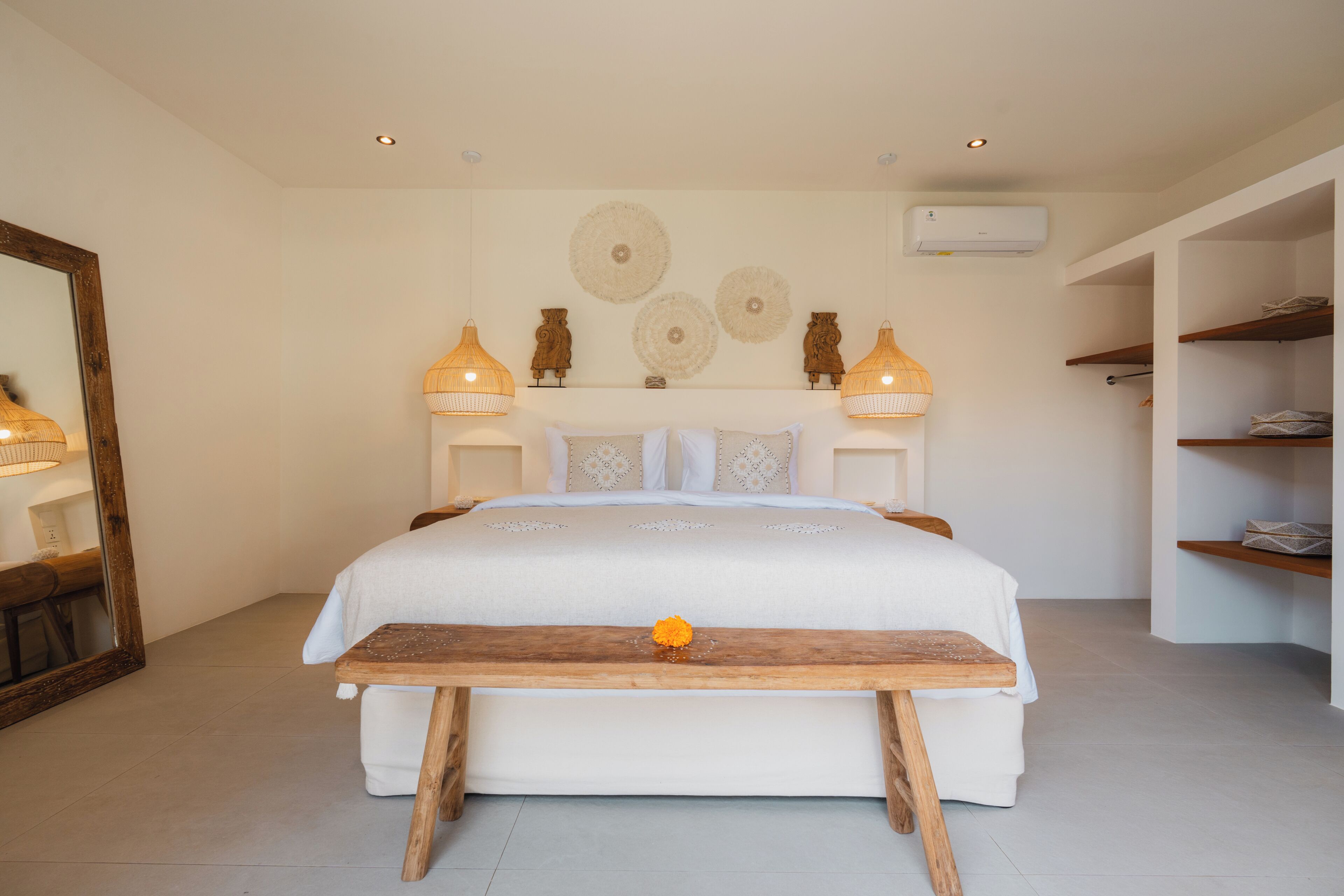 A bedroom with a bed, bedside lamps, a wooden table, and wall decor.