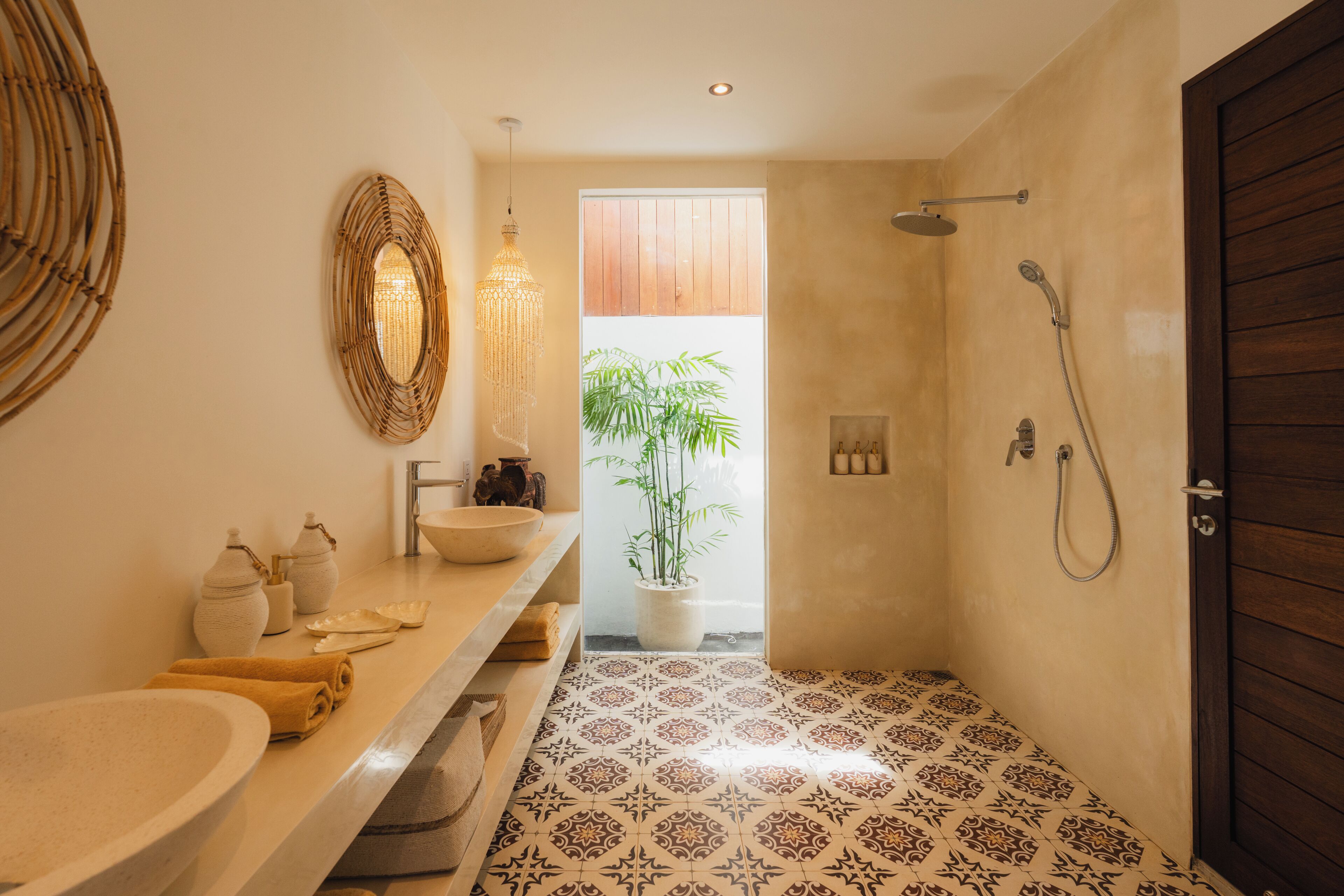 Ein Badezimmer mit einem großen Waschbecken, einem Spiegel, einer Dusche und einem Blumentopf.